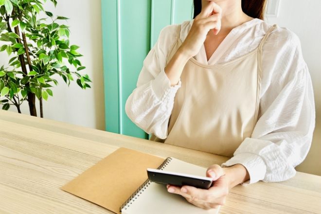 電卓を手に悩んでいる女性。夫が配信者に多額課金…最近は外出も増え、不倫の疑いが拭えません|30代女性からの調査相談。