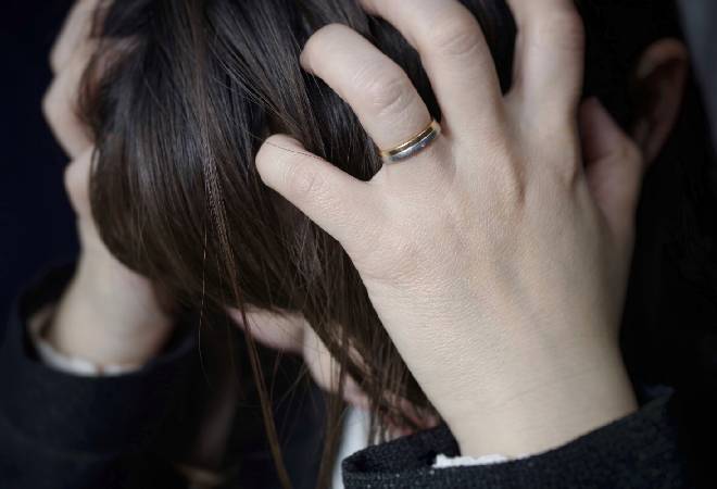 頭を抱える女性。