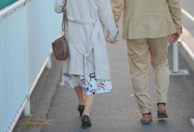 手をつなぐ男女の後ろ姿。