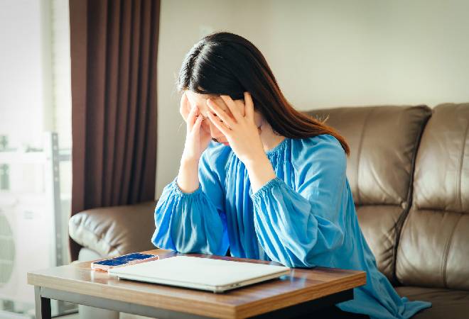 頭を抱える女性の姿。