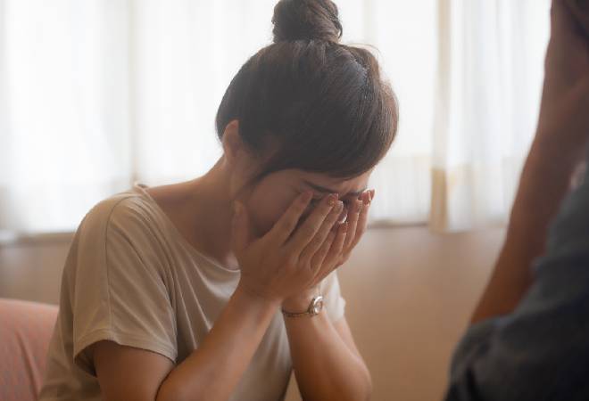 泣きながら相談する女性の姿。