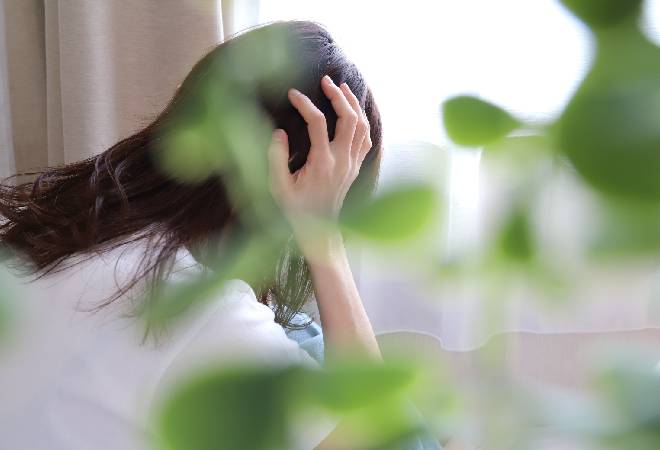 悩む女性の後ろ姿。