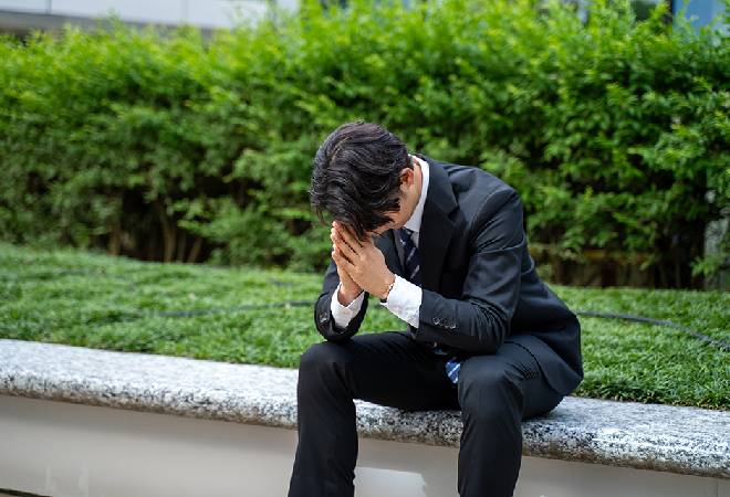 落ち込むスーツ姿の男性。