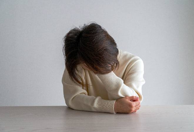 悩み苦しむ女性の姿。