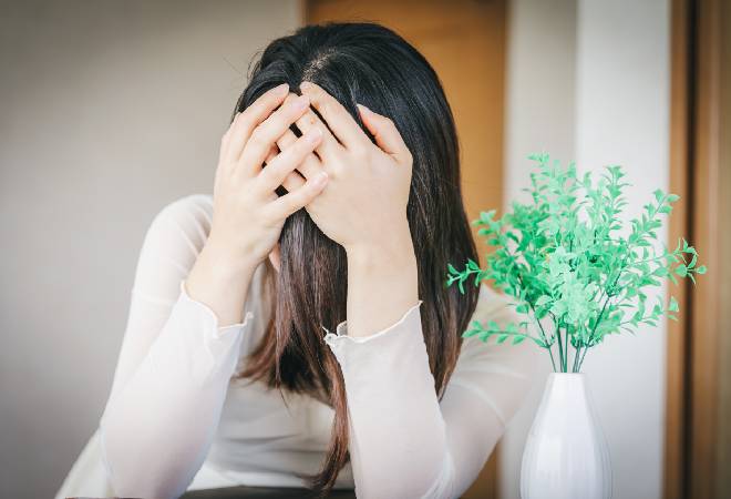 悩み苦しむ女性の姿。
