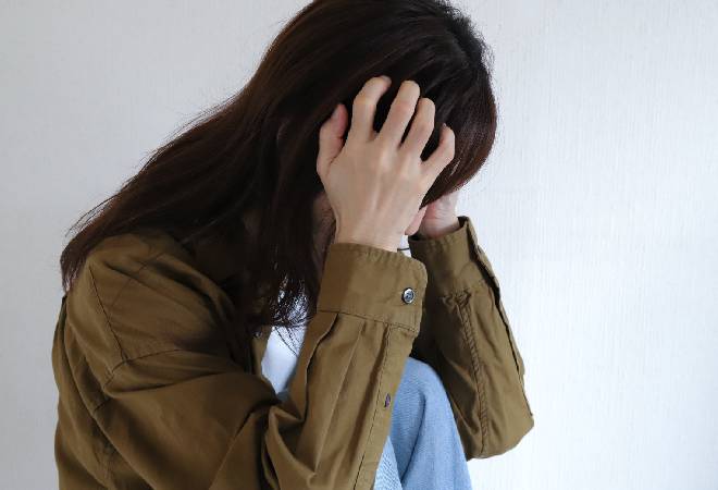 頭を抱える女性の姿。
