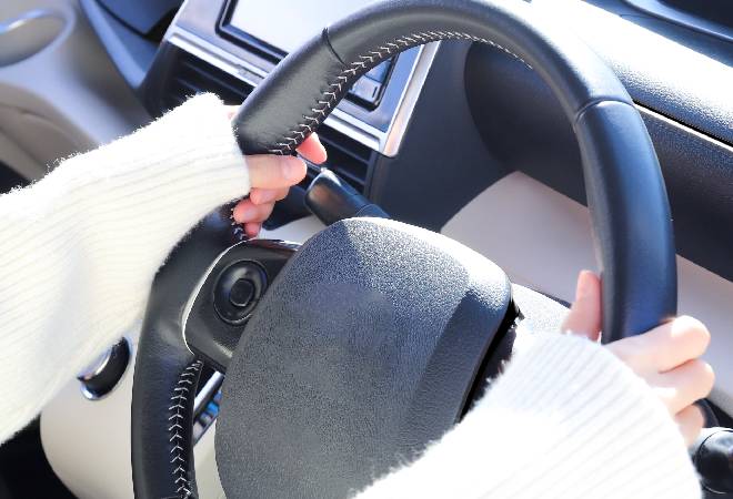 運転席と女性の手。